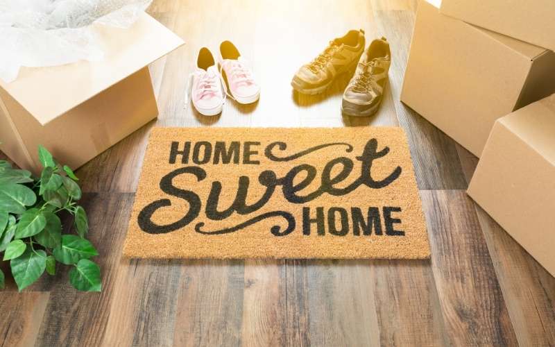 Doormat reading 'Home Sweet Home' with shoes next to it