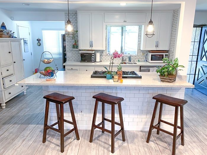 A white granite kitchen island with white subway tiles