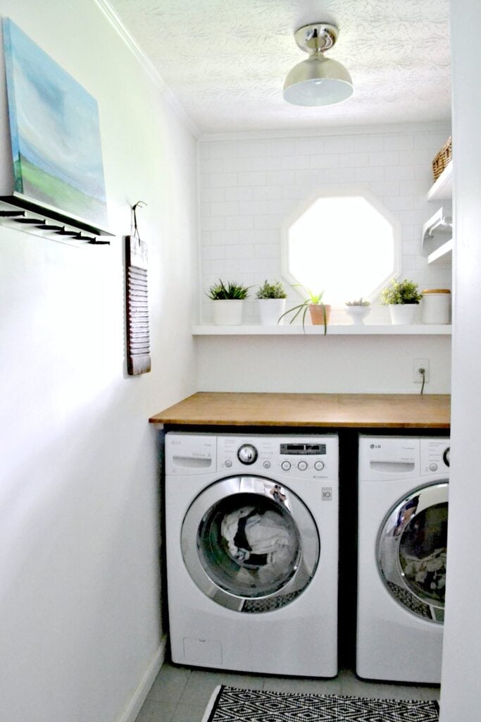 A laundry room with white bricks on the wall