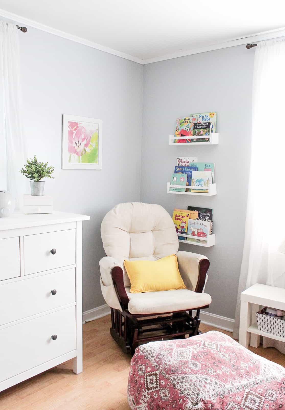 A rocking chair and books on the wall in a nursery 