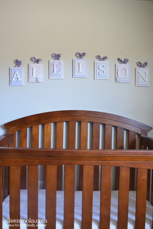 A wall behind the crib that says Allison