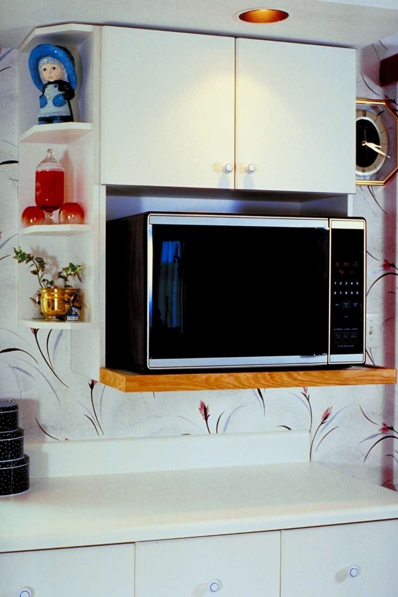 A great option for those wondering where to put microwave in small kitchen is to use shelving place the microwave under high cabinets.