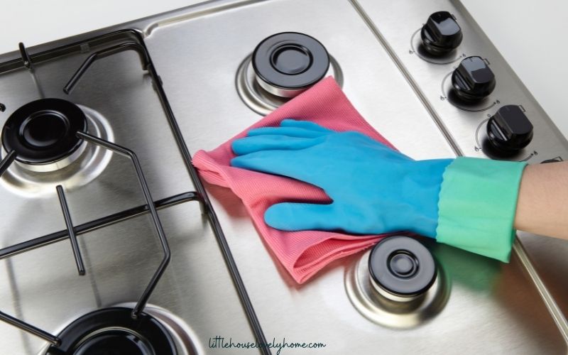 Stovetop and hand with gloves cleaning