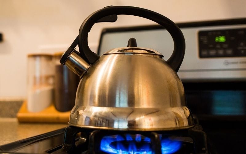 Image of a kettle over a stove with fire