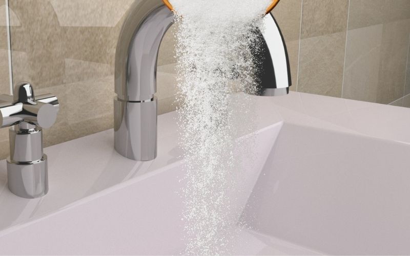 Image of a white sink with white powder being poured