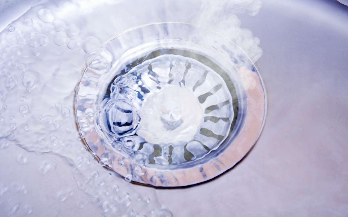 Image of hot water pouring over the drain