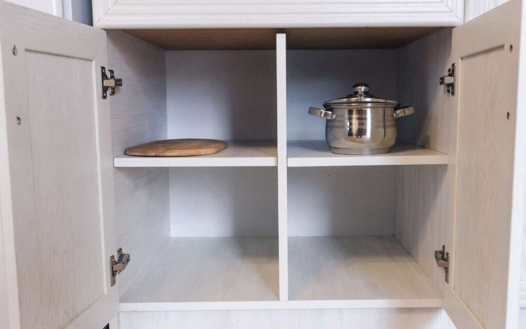 Image of an opened cabinet with a pan inside