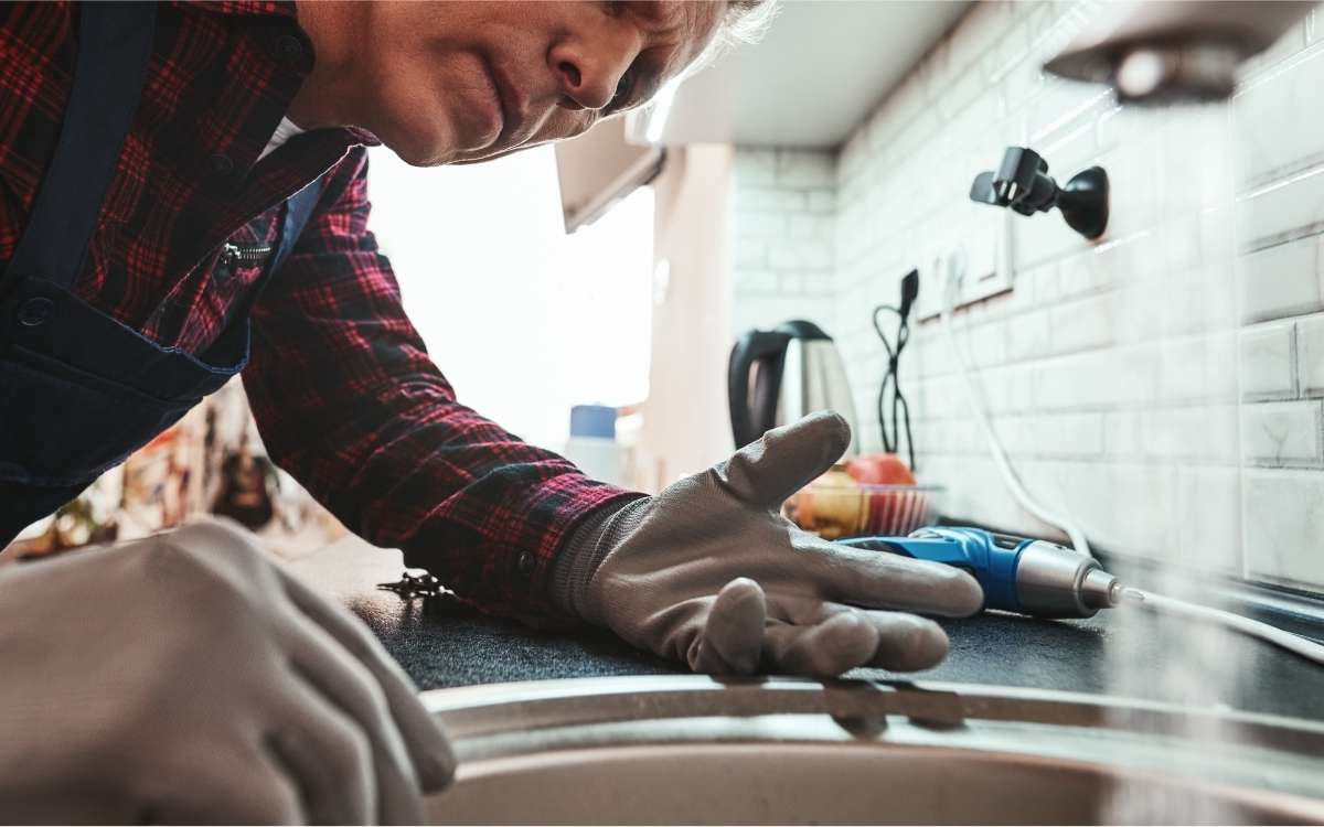 Image of a man looking at the sink with running water from the faucet
