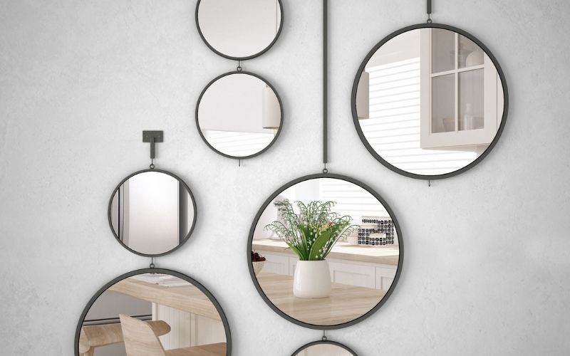 Photo of several round mirrors hanging on a wall