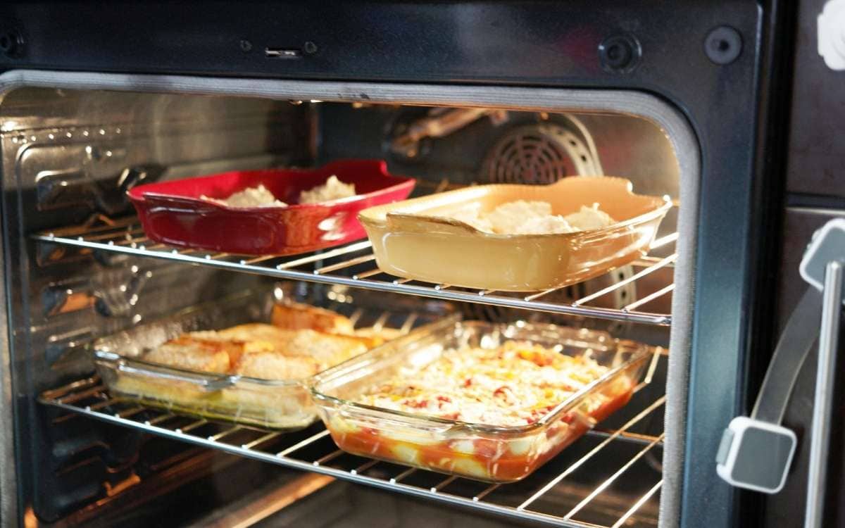 Image of four baking wares with food inside an oven