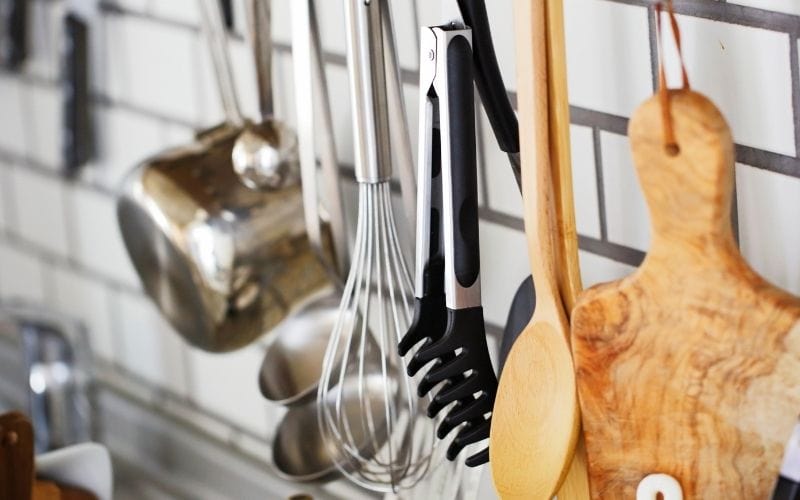 Photo of a pot and other kitchen utensils hanging in the kitchen