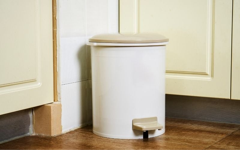 Photo of a trash can with cover on the floor