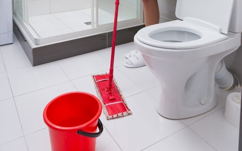 Image of the bathroom floor where a person is mopping the floor
