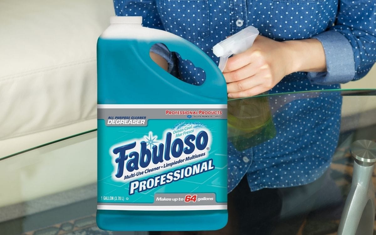 Image showing a gallon of fabuloso and a person holding a spray beside a glass top