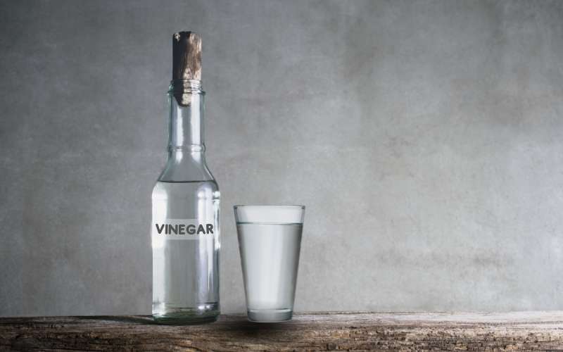Photo of a bottle of vinegar and a glass of water