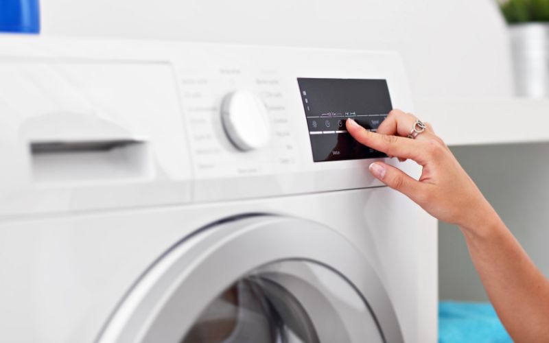 Image showing a hand setting the washing machine