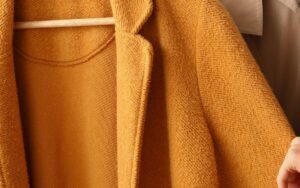 A brown jacket cleaned and hanged in a wooden hanger