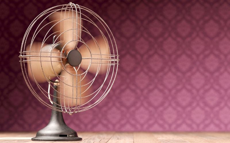 An electric fan with maroon background