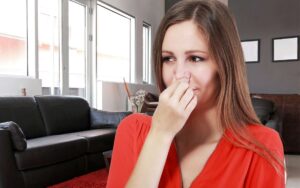 A woman covering her nose as if the house smells bad